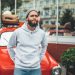 homme porte sweatshirt capuche hoodie gris
